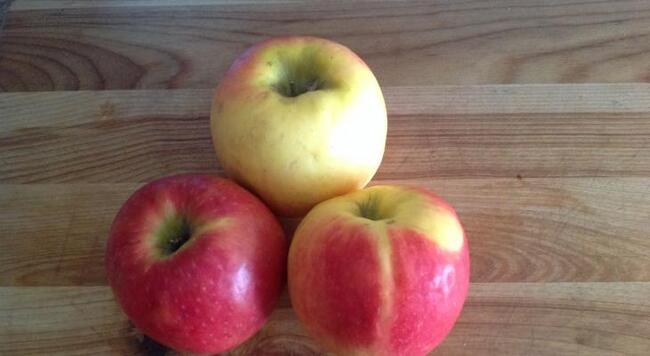 Three apples on wood background